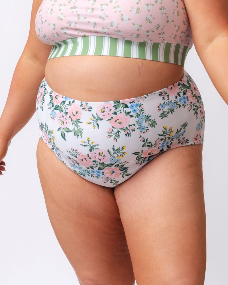 Close up photo of a woman wearing pink and white floral high waist swim bottoms