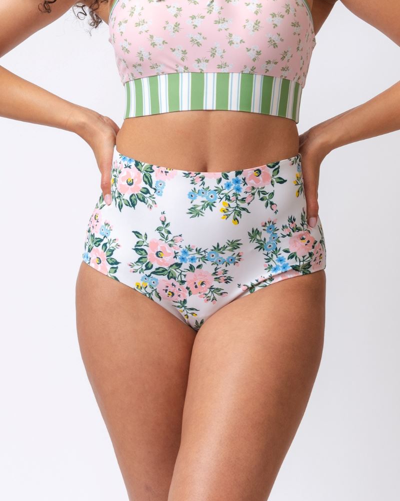 Close up photo of a woman wearing pink and white floral reversible high waist swim bottoms