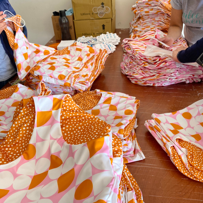 Photo of pink, orange, and white geometrical high waist swim bottoms laying on table