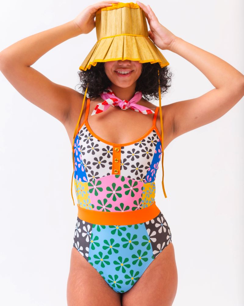 Photo of a woman wearing a multi-colored floral one-piece swimsuit