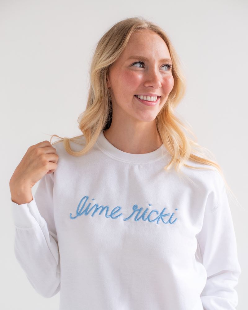 Photo of woman smiling wearing a Lime Ricki white crew neck sweatshirt