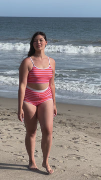 Video of a woman wearing a Sherbet stripe retro swim short bottom and a sherbet stripe swim bralette