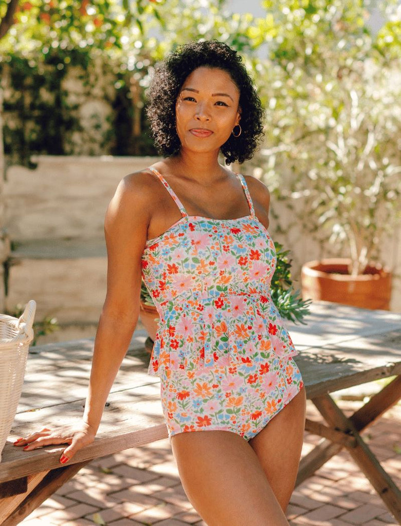 Photo of a woman wearing a floral peplum swim top and a floral swim bottom