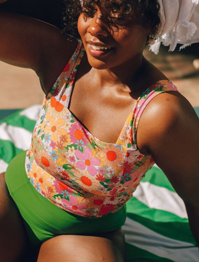 Photo of woman wearing multi colored cropped square neck swim top with green swim bottoms