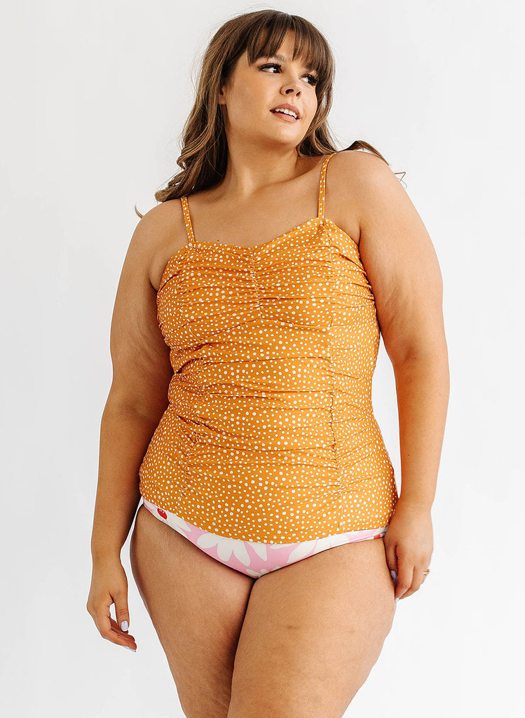 Photo of woman wearing orange and white dot swim tankini with pink floral swim bottoms
