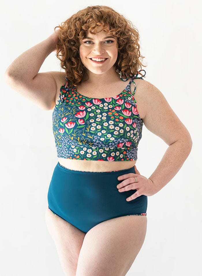 Photo of a woman wearing a Blixen shoulder-tie swim crop top and an indigo swim bottom