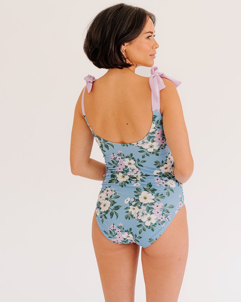 Photo of a woman wearing a Briar shoulder-tie one-piece swimsuit back angle