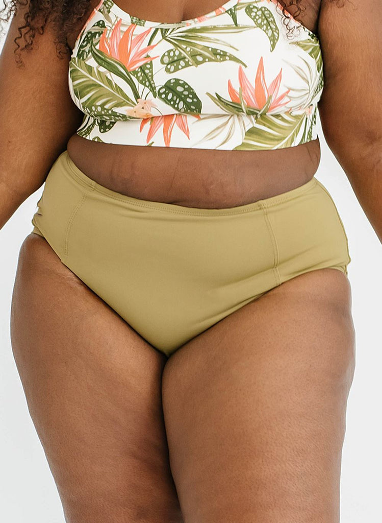Photo of woman wearing multi colored floral swim top with green swim bottoms