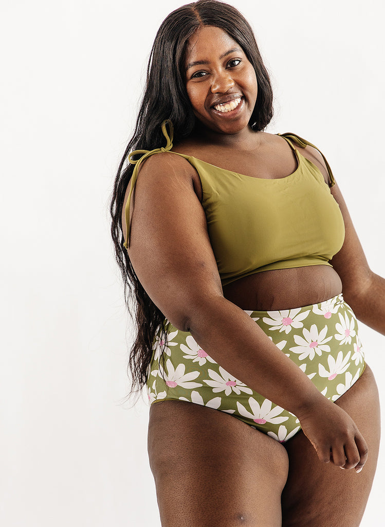 Photo of woman wearing green cropped swim top with green and white floral swim bottoms