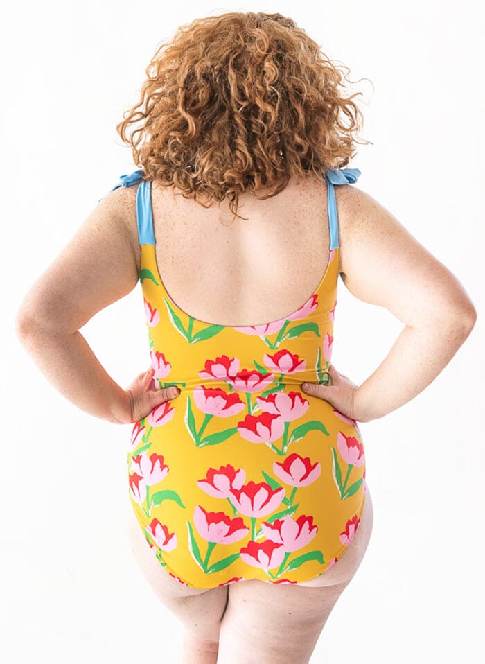 Photo of a woman wearing a Claus shoulder-tie one-piece swim suit back angle
