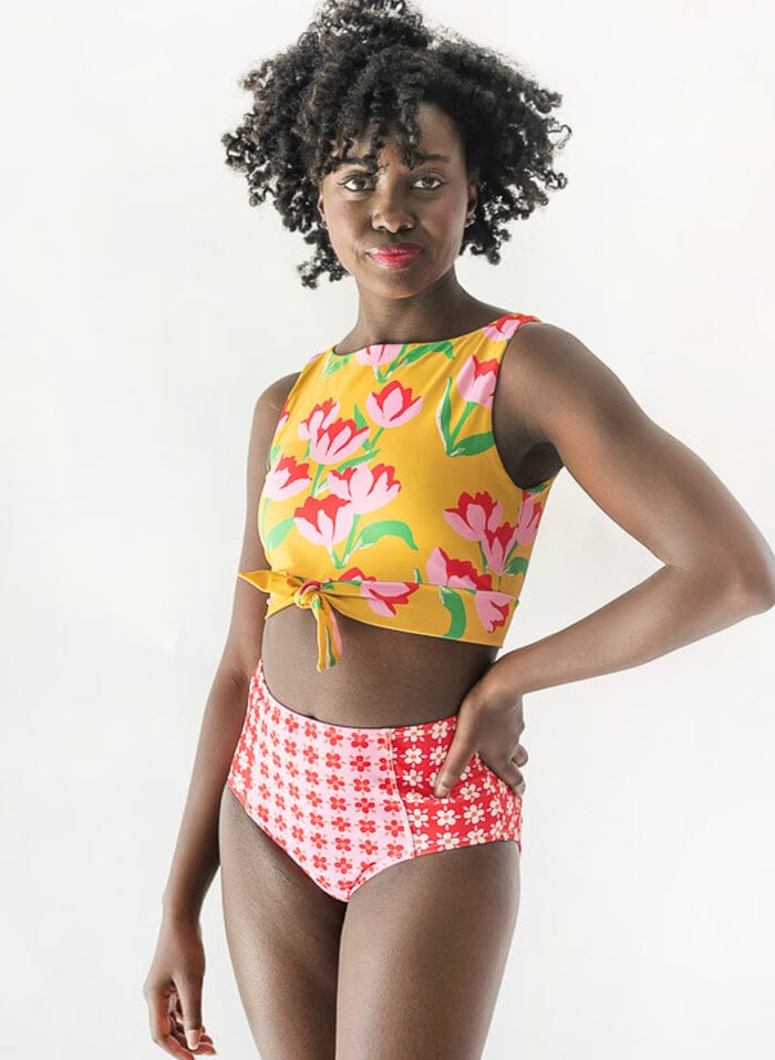 Photo of a woman wearing a Claus swim crop top and a floral swim bottom