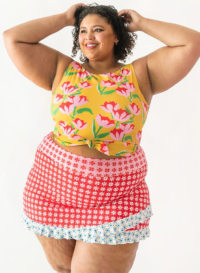 Photo of a woman wearing a Claus swim crop top and a floral swim skirt bottom