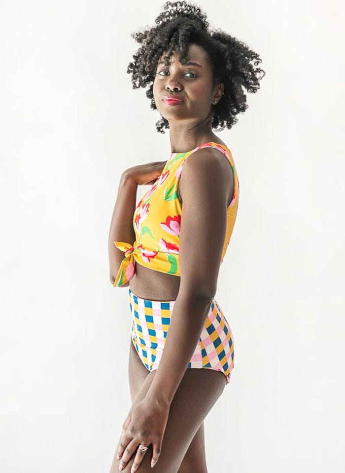 Photo of a woman wearing a Claus/Tage reversible swim bottom checkered side and a Clause swim crop top side angle
