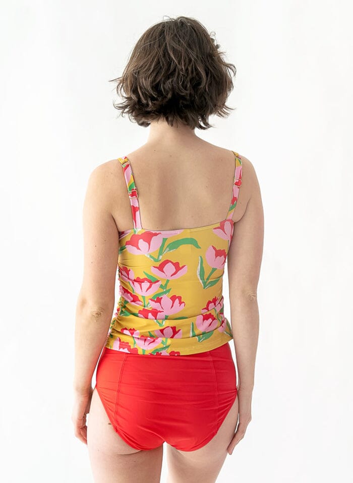 of a woman wearing a Claus square-neck swim top and a red swim bottom back angle