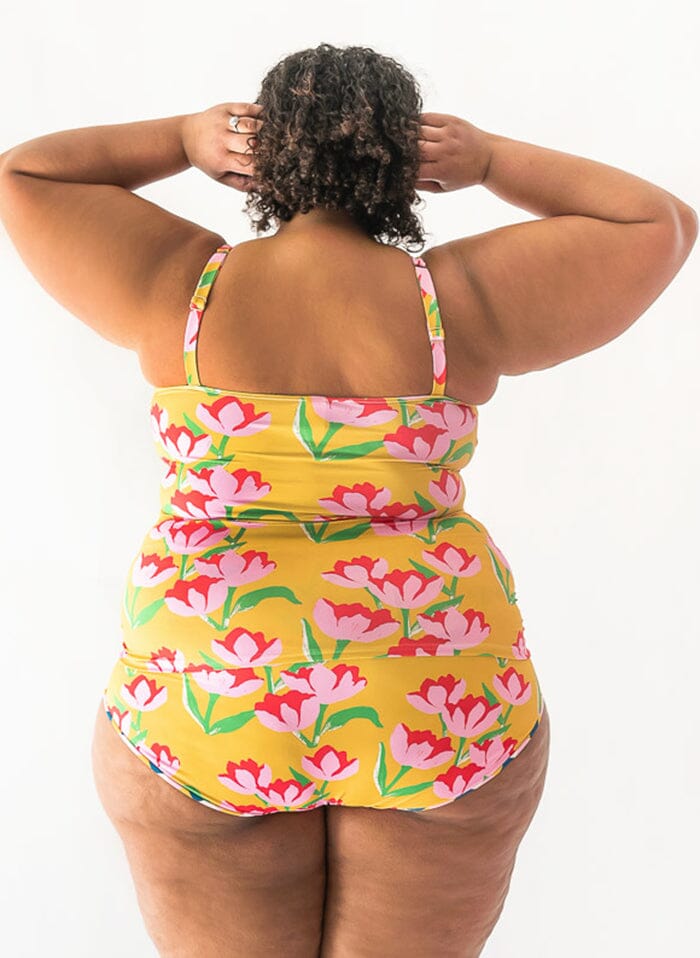 of a woman wearing a Claus square-neck swim top and a Claus swim bottom back angle