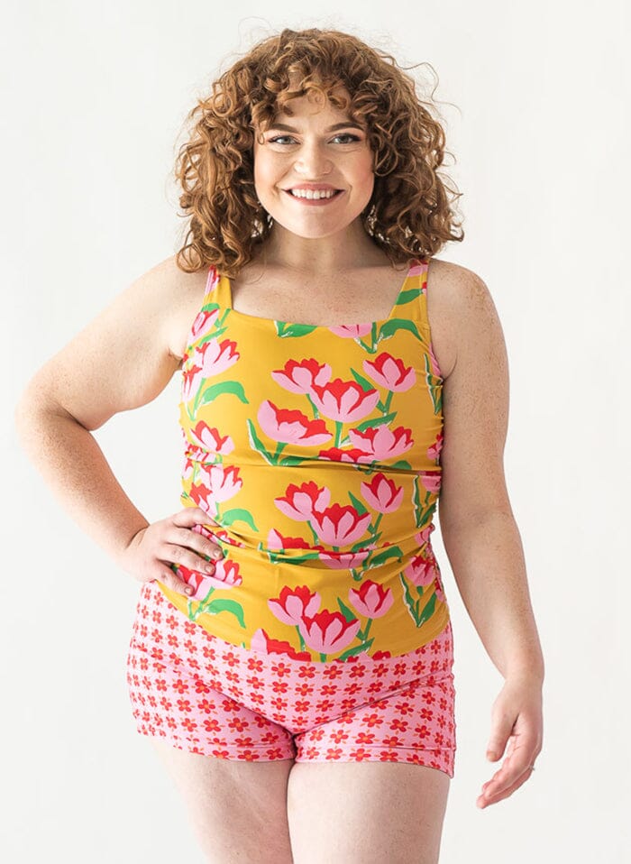 of a woman wearing a Claus square-neck swim top and a floral swim short bottom