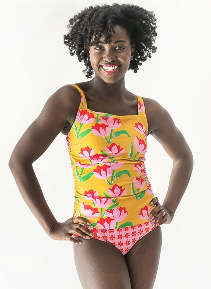 Photo of a woman wearing a Claus square-neck swim top and a floral swim bottom