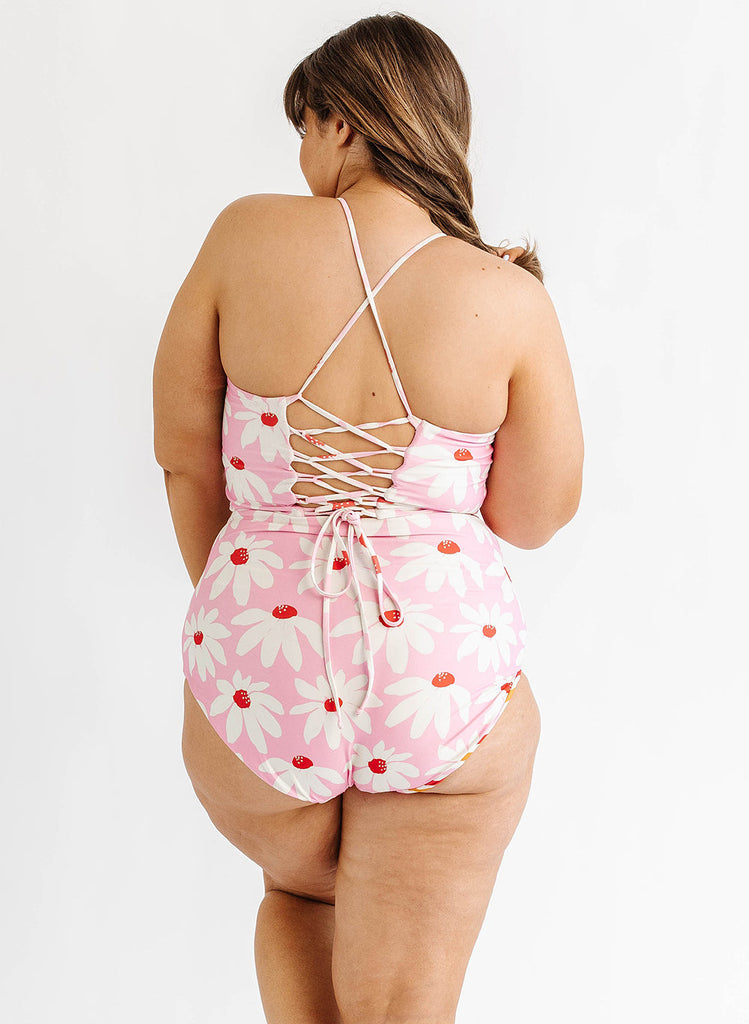 Photo of woman wearing pink floral lace back swim top with pink floral swim bottoms back angle