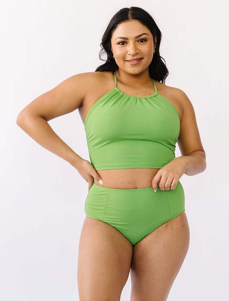Photo of woman wearing green cropped lace back swim top with green swim bottoms