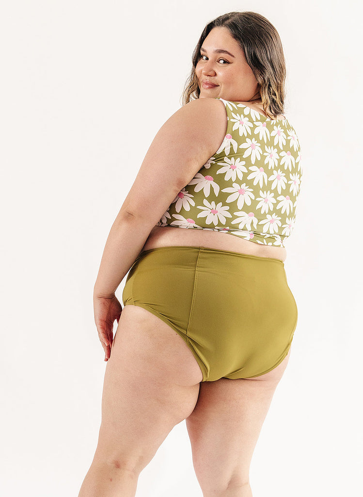 Photo of woman wearing green and white floral cropped swim top with green swim bottoms back angle