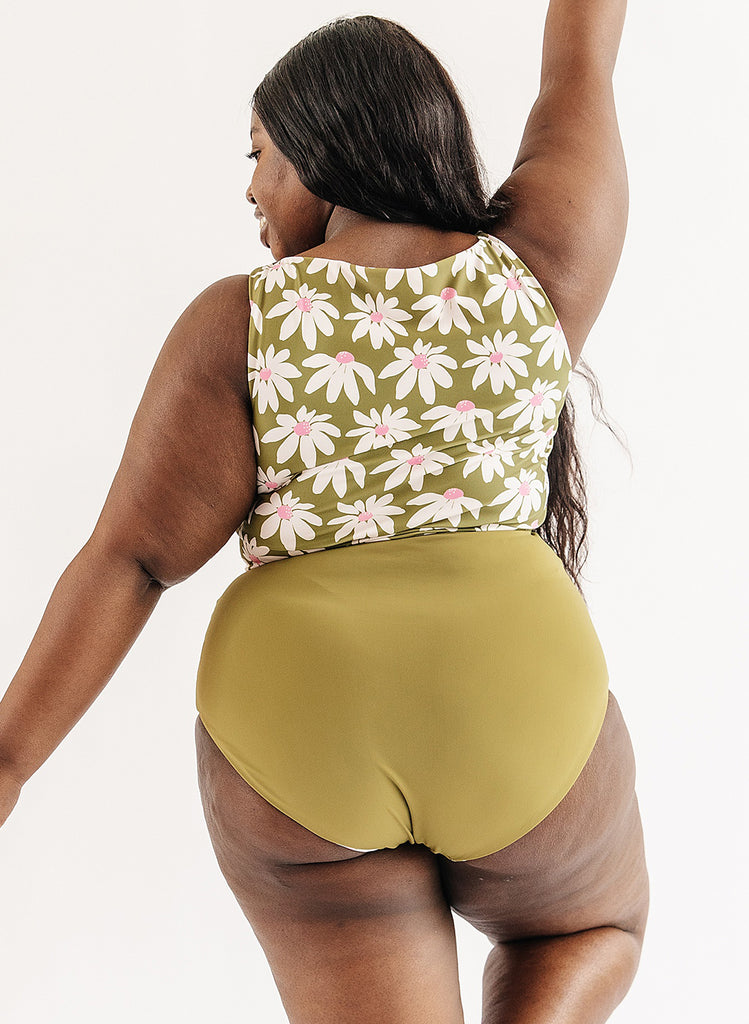 Photo of woman wearing green and white floral cropped swim top with green swim bottoms back angle