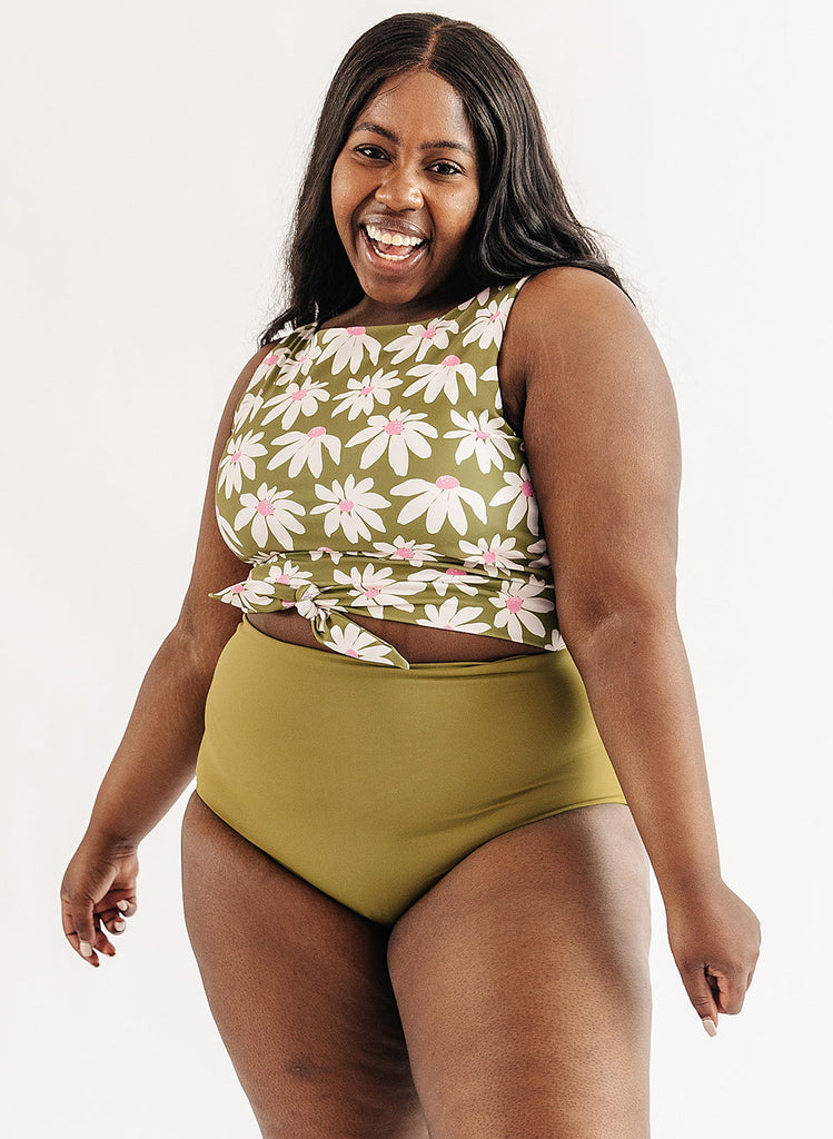 Photo of woman wearing green and white floral cropped swim top with green swim bottoms