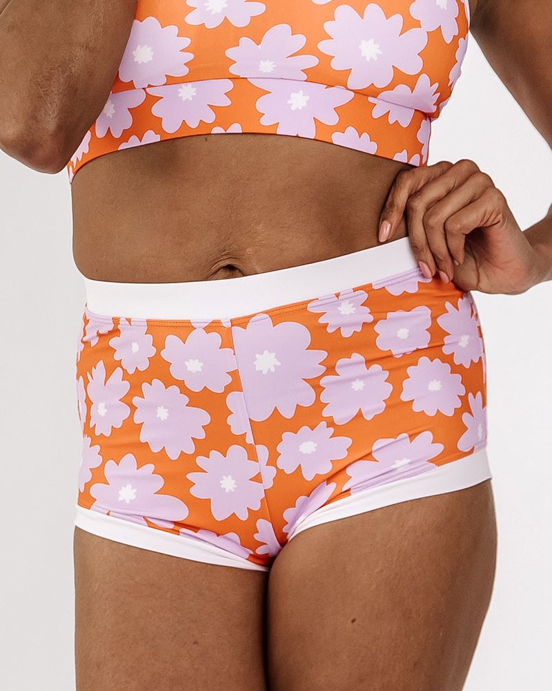 Photo of a woman wearing a Daphne floral retro swim short bottom and a Daphne floral swim bralette