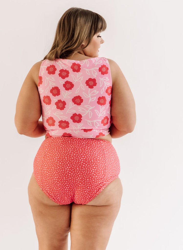 Photo of a woman wearing a Ditsy floral knotted swim crop top and a red and white dotted swim bottom back angel