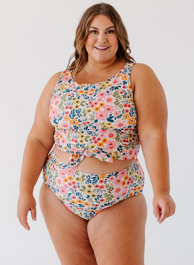 Photo of woman wearing a multi colored floral cropped swim top with multi colored floral high waist swim bottoms