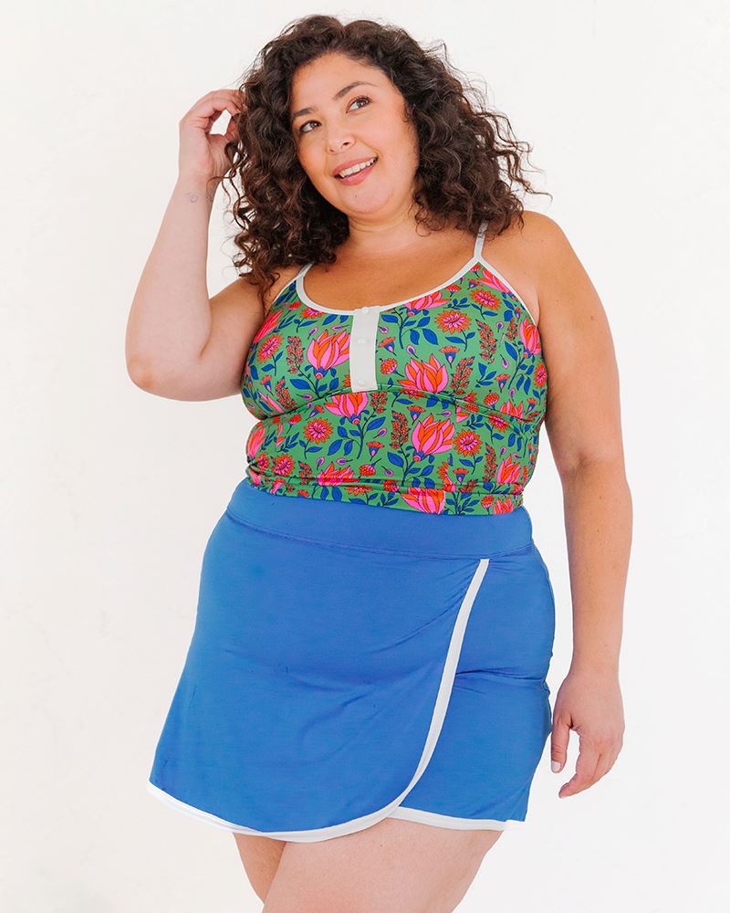 Photo of a woman wearing a Fresco Floral swim crop top and a Capri swim skirt