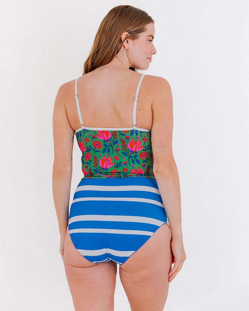 Photo of a woman wearing a Capri/Capri stripe reversible swim bottom stripe side and a Fresco floral swim crop top back angle