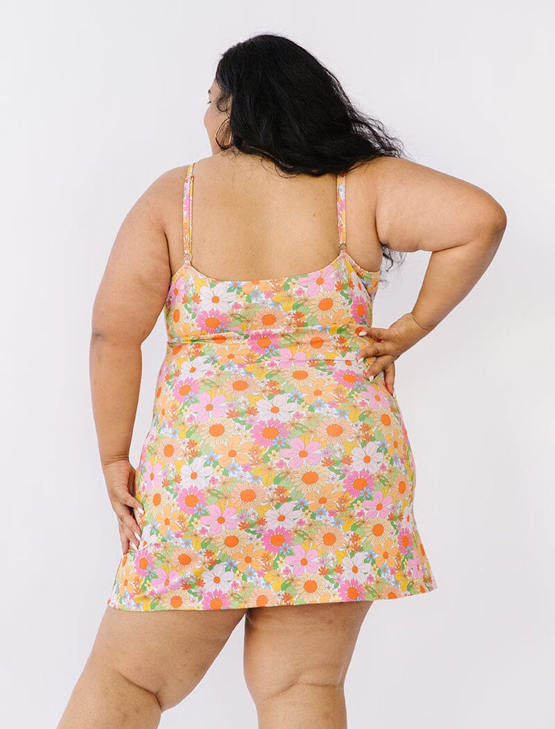 Photo of woman wearing multi colored floral swim dress back angle