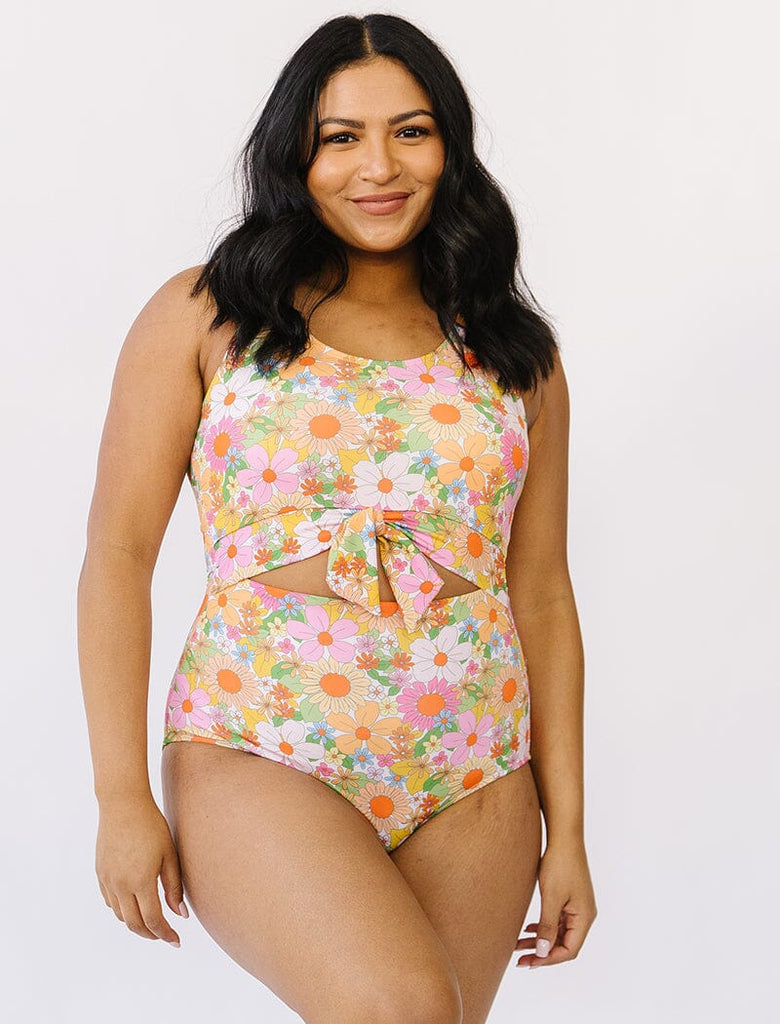 Photo of woman wearing multi colored floral knotted swim one piece