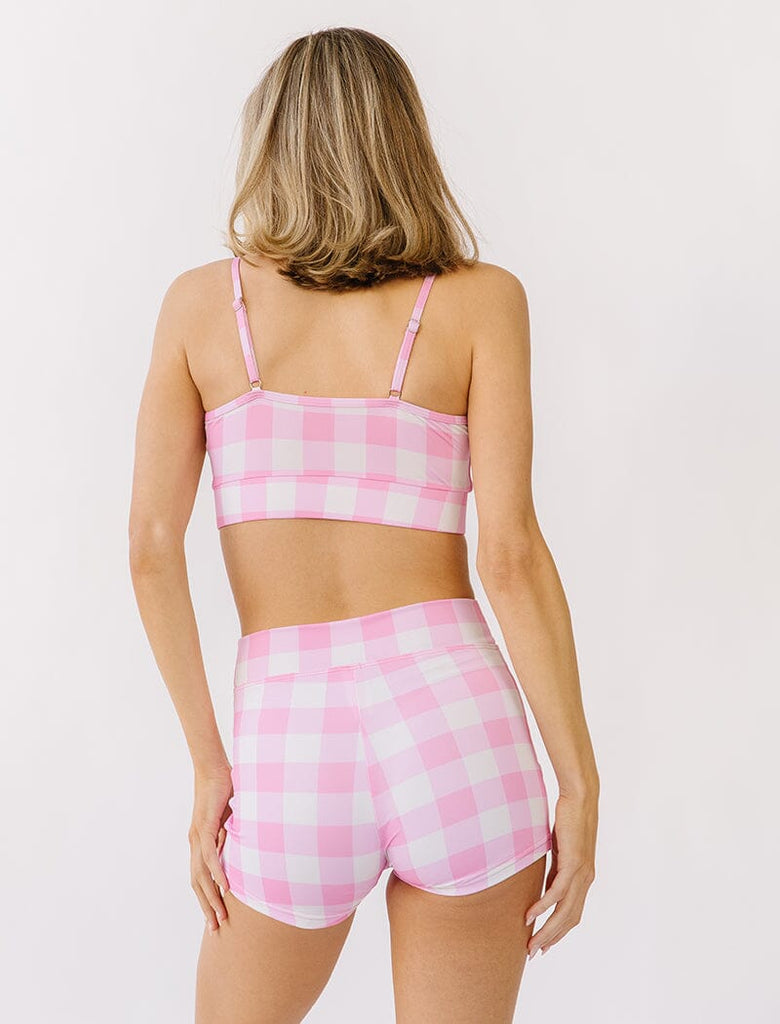Photo of woman wearing pink gingham bralette swim top with pink gingham swim shorts back angle