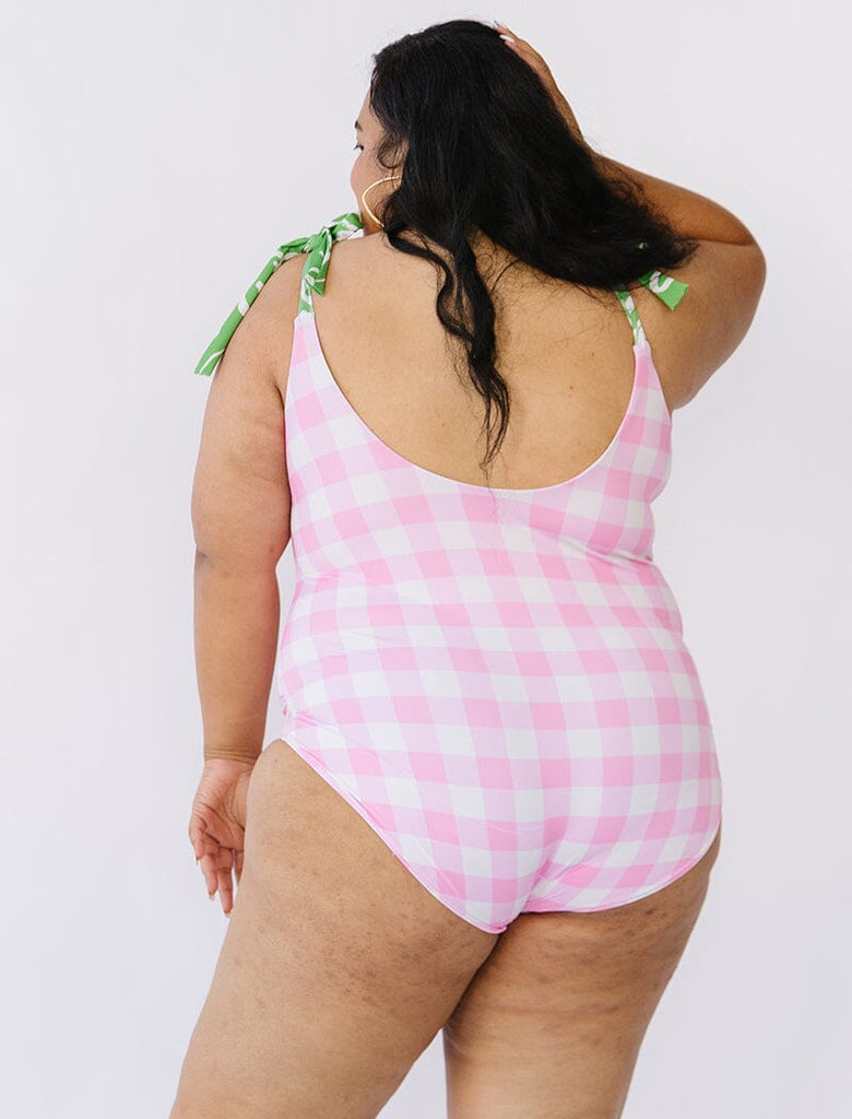 Photo of woman wearing pink gingham swim one piece back angle
