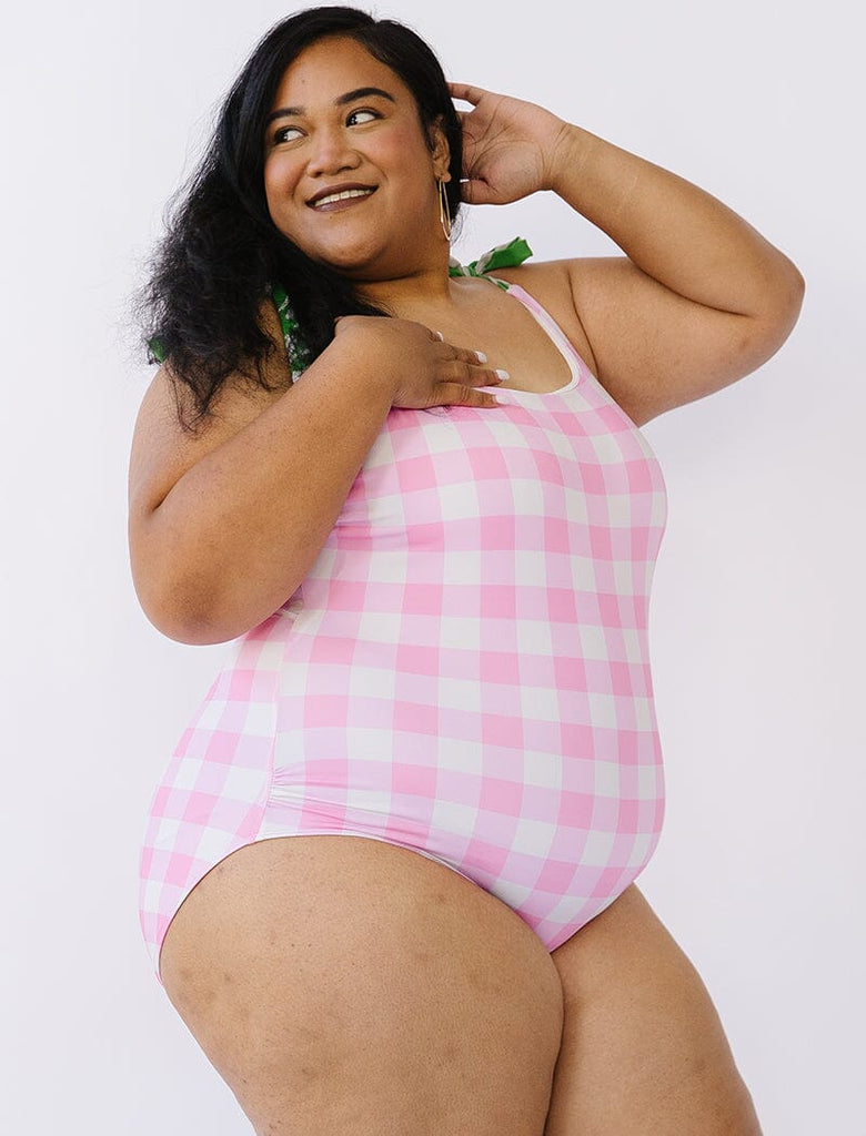 Photo of woman wearing pink gingham swim one piece side angle