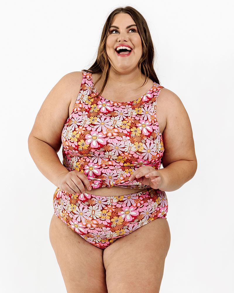 Photo of a woman wearing a Groovy Blooms floral knotted swim crop top and a Groovy Blooms floral swim bottom