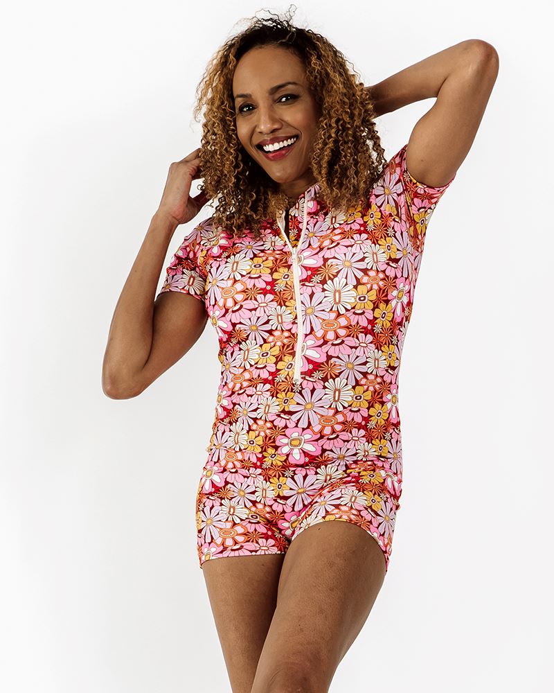 Photo of a woman wearing a groovy Blooms floral rash guard one-piece swim suit