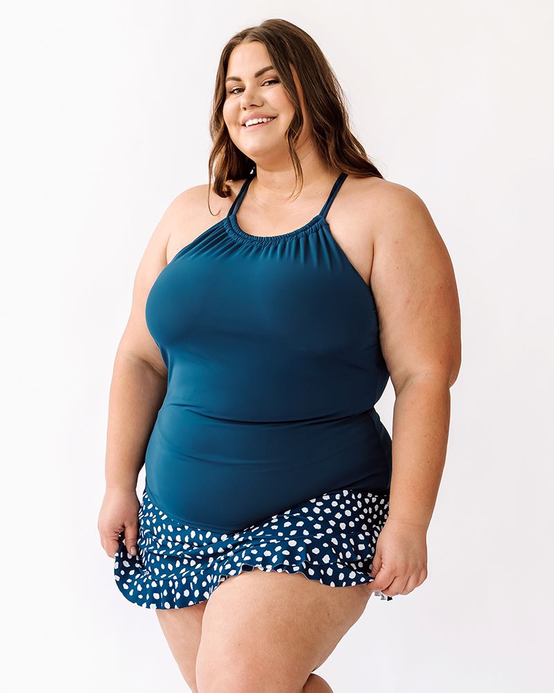 Photo of a woman wearing an Indigo double-cinch swim top and an indigo dot swim skirt bottom