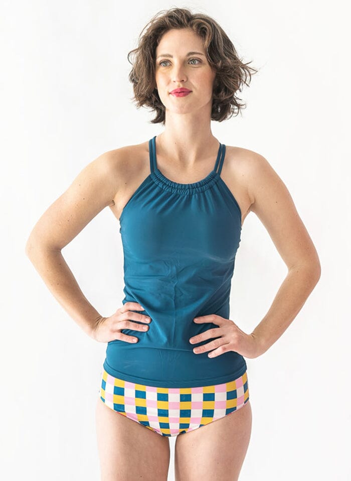 Photo of a woman wearing an Indigo double-cinch swim top and a multi color checkered swim bottom