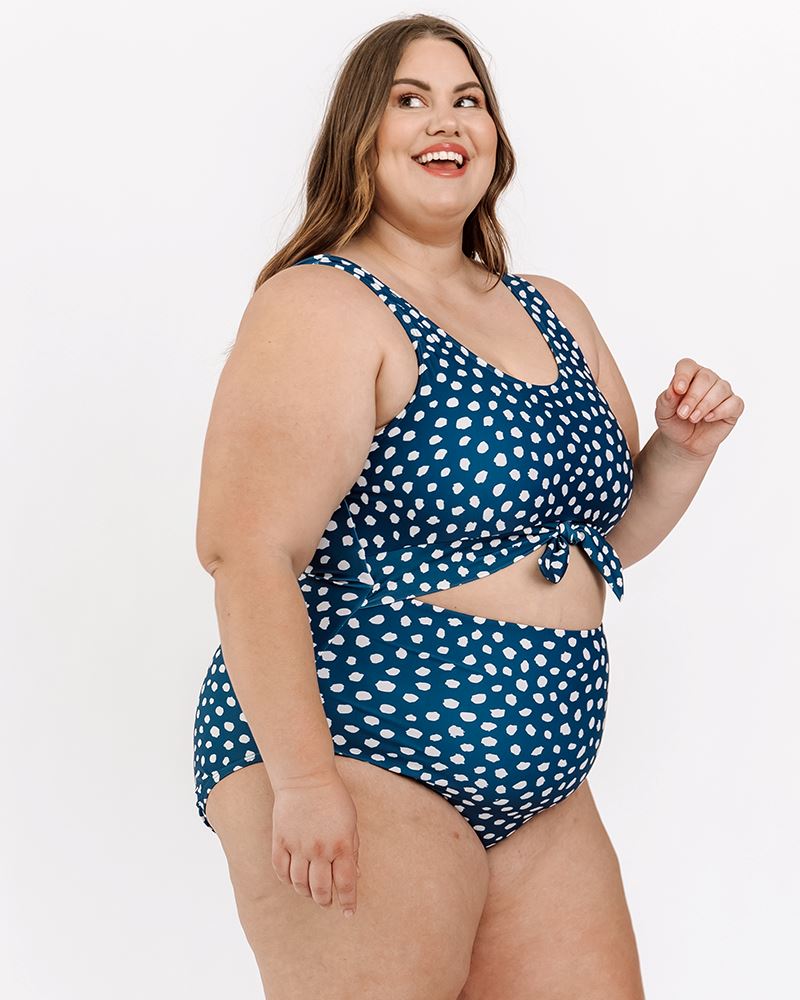 Photo of a woman wearing an Indigo dot knotted one-piece swim suit side angle
