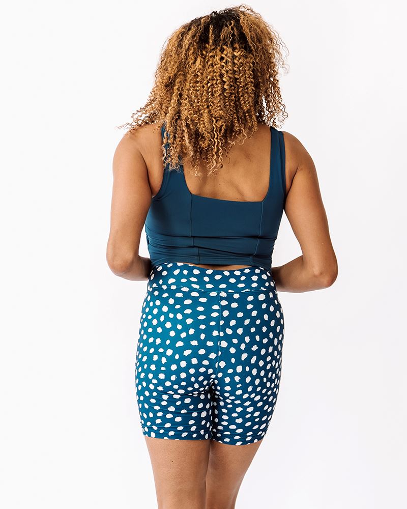 Photo of a woman wearing an Indigo dot Swim bike short and an Indigo square neck swim crop top back angle