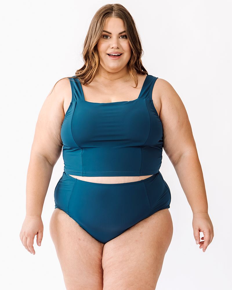 Photo of woman wearing blue square neck cropped swim top with blue high waisted swim bottoms