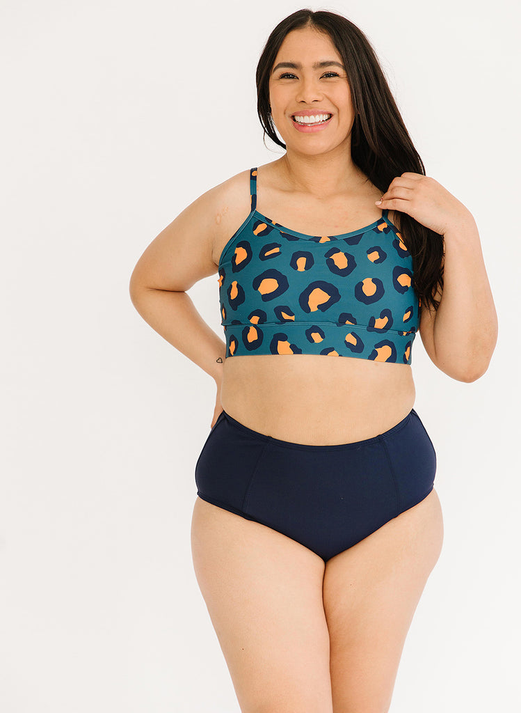 Photo of woman wearing a blue leopard cropped swim top with blue high waist swim bottoms
