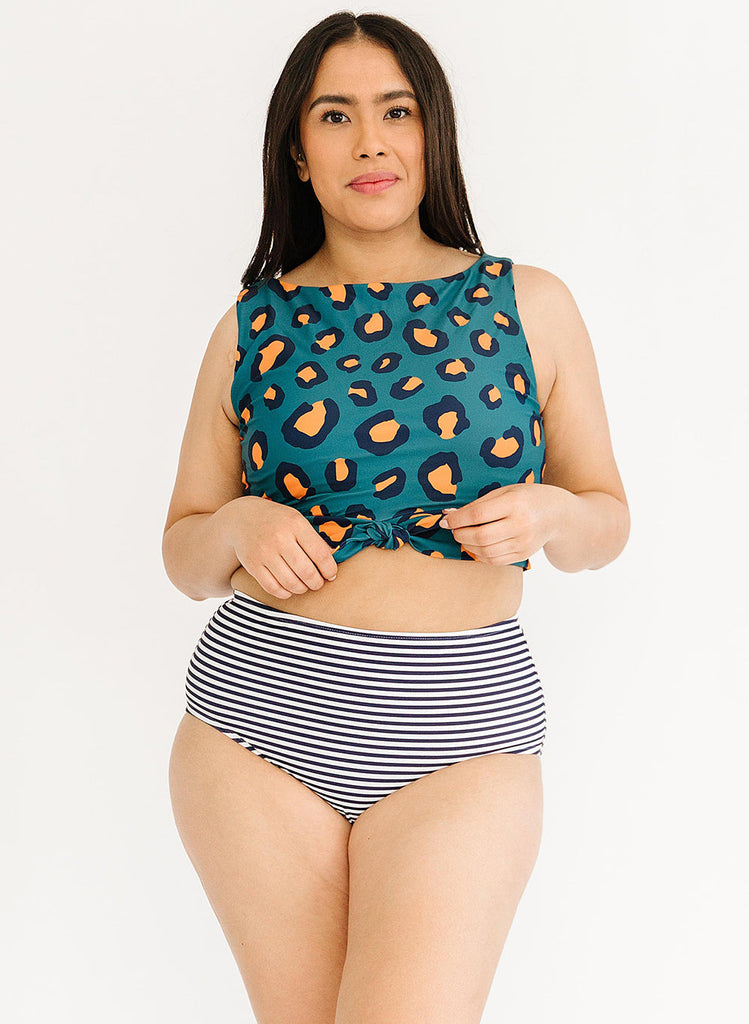 Photo of a woman wearing a blue leopard print cropped swim top with blue and white striped high waist swim bottoms
