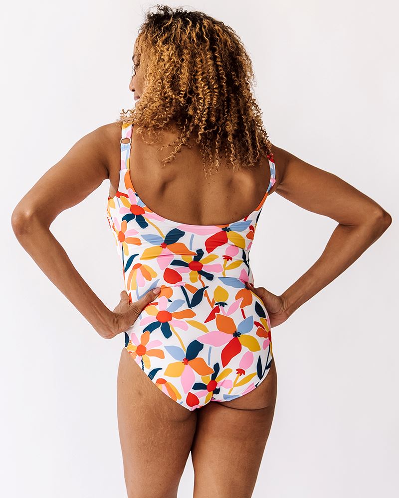 Photo of a woman wearing a June floral one-piece swim suit back angle