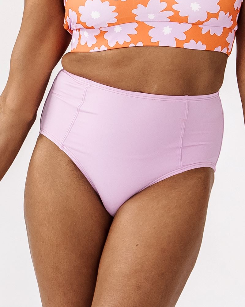 Photo of a woman wearing a Lilac swim bottom and a Daphne floral swim top