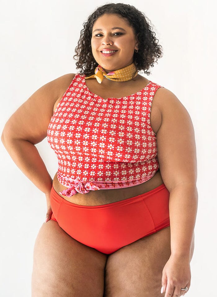 Photo of a woman wearing a red swim bottom and a red floral swim crop top