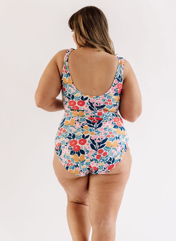 Photo of a woman wearing a May Flowers knotted one-piece swim suit back angle