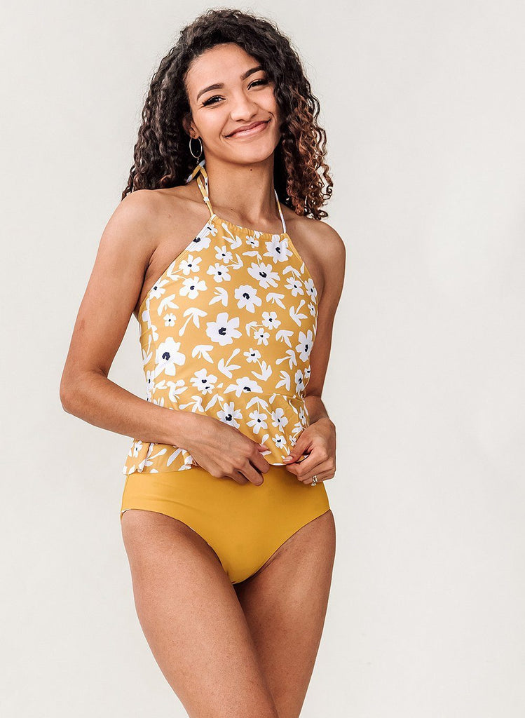 Photo of a woman wearing a yellow floral swim top with yellow high waist swim bottoms